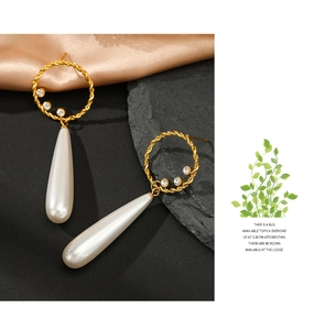 Detail of 14K gold-plated hoop earrings with sparkling zircon and teardrop pearls