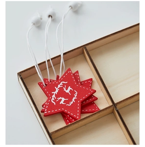 Close-up of red wooden star ornament with reindeer print and white hanging bead
