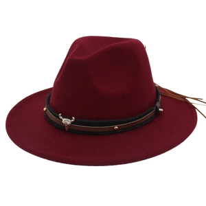 Close-up of wine red fedora with cow skull metal pendant and leather tassel details