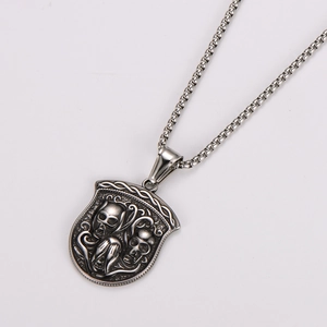 Détail d'un pendentif bouclier en argent vieilli avec relief de crâne et de serpent