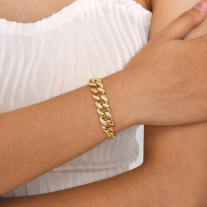 Nahaufnahme eines goldfarbenen Panzerarmbands mit Zirkonia-Steinen am Handgelenk