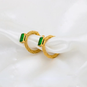 Elegant C-shaped gold textured earrings with green rectangular zircon on white silk