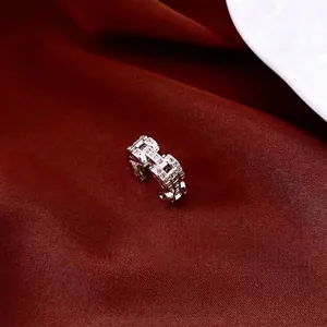 Sparkling silver swan zircon ear cuff earring on red silk fabric background for women