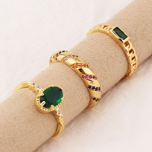 Three-piece gold ring set with emerald zircon and colorful stones on a jewelry display