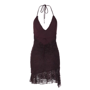 Détail d'une robe en dentelle violet foncé avec dos nu et ourlet à volants sur fond blanc