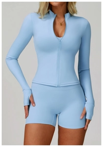 Dettaglio di set fitness celeste con top a maniche lunghe e pantaloncini a vita alta