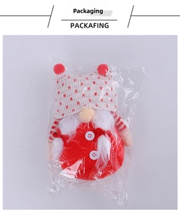 Detail view of a knitted Christmas gnome in clear packaging with red heart patterns