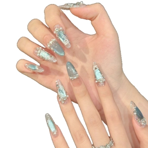Unghie finte blu cat eye con perle e rilievi floreali in forma a mandorla lunga