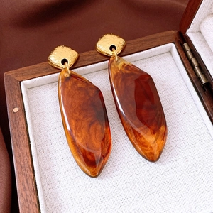 Macro shot of vintage tiger eye stone earrings in a wooden jewelry display box