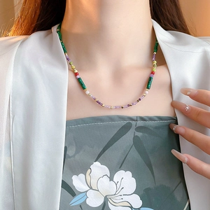 Detailed close-up of mixed natural stones and shell pearls on a gold-plated beaded necklace