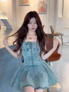 Detail of light blue denim strapless dress with corset lace-up and gold butterfly pendant