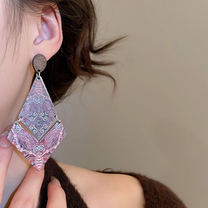 Close-up of lightweight wood diamond earrings with purple mandala print on a female model