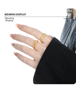 Detail view of two gold lava textured rings with zircon stones on model's hand