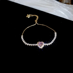 Dettaglio del bracciale regolabile in oro con pietra a cuore rosa e zirconi cubici bianchi