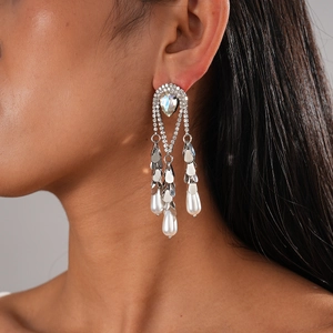 Détail de boucles d'oreilles plaquées or 18k avec glands strass et perles blanches