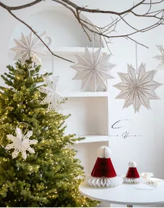 Détail de flocons de neige en papier découpé au laser sur un sapin de Noël illuminé