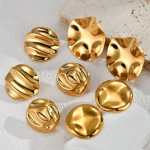 Detailed view of irregular textured 18K gold-plated stainless steel earrings on stone