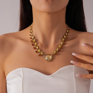 Vintage gold wheat leaf necklace with amber teardrop crystals on female model neck