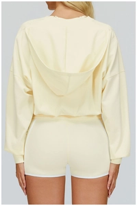Rear view of a light yellow hooded sweatshirt and matching shorts with white piping
