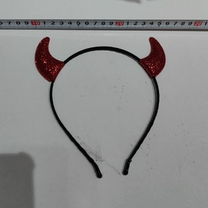 Detail of red glitter devil horn headband with measuring tape showing size measurements