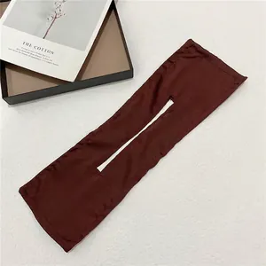 Detail view of dark coffee fabric hair bun maker with central slit on white surface