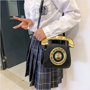 Close-up of a retro telephone crossbody bag featuring a vintage rotary dial design