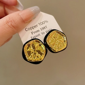 Macro detail of French vintage earrings made of 100% copper with hammered gold texture
