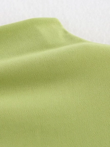 Macro della trama del tessuto a maglia verde erba che mostra la finezza delle fibre morbide