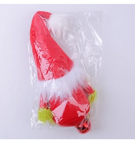 Detail of a Christmas Grinch gnome doll with green beard and red heart in clear packaging