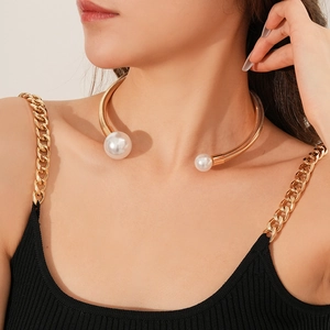Detailed close-up of a gold metal choker with pearl accents on a woman's neck