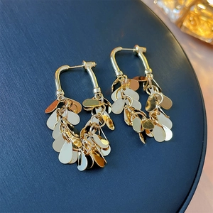 Close-up of golden U-shaped earrings with cascading water-drop metal sequins