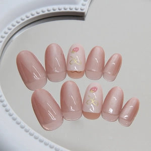 Pink cat eye press-on nails set featuring cute strawberry and golden bow designs