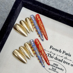 Handmade stiletto press-on nails featuring royal blue and gold luxury art designs