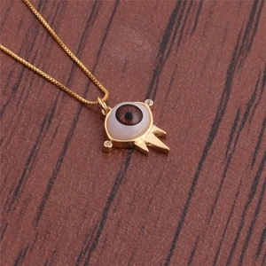 Macro detail of evil eye pendant in copper with brown resin pupil and tiny zircon accents