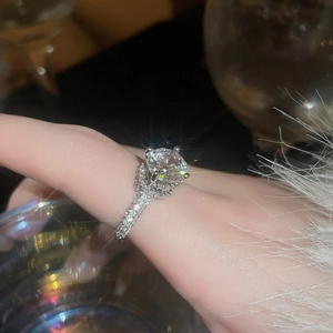 Detailed view of silver zircon ring with round center stone and pave-set band on finger