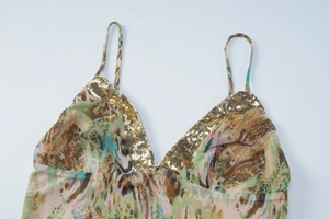 Detail view of V-neck sequin stitching and mesh fabric on a printed camisole