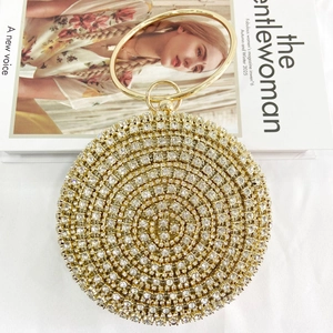 Detailed shot of gold rhinestone evening clutch with large metal circular handle and sparkles