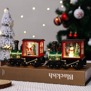 Detailed view of two Christmas train snow globes with Santa and Snowman figurines.