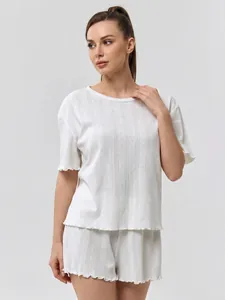 Detail of white cotton loungewear set featuring vertical stripes and wavy lettuce edges