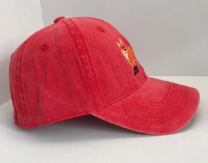 Detail of red washed cotton baseball cap featuring pixelated fox embroidery on the side