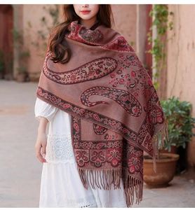 Dettaglio scialle bohémien rosso in cashmere con motivi paisley e nappe a mano