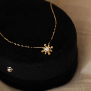 Macro shot of 18K gold sunflower necklace featuring an iridescent faux opal centerpiece