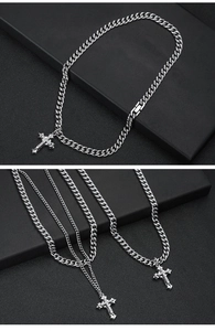 Macro shot of double layered silver Cuban link necklace with iced out cross pendant