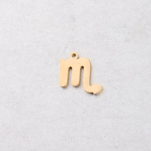 Close-up of a 15mm golden stainless steel Scorpio zodiac charm with a polished mirror finish