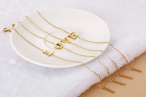 Detail of gold LOVE letter bracelets with crystals on a white ceramic plate