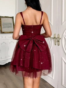 Detail of burgundy evening dress featuring a large back bow and sparkling sequins