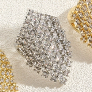 Macro shot of silver and gold geometric rings with sparkling cubic zirconia inlay