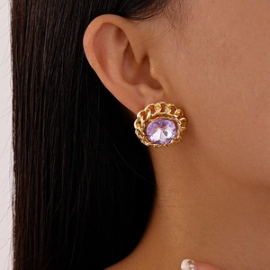 Detail of vintage gold-tone chain earring featuring a large purple faceted gemstone