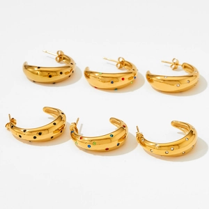 Boucles d'oreilles dorées en C serties de zircons colorés sur surfaces métalliques bombées