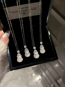 Detailed macro view of four stainless steel gourd necklaces with white zircon pendants